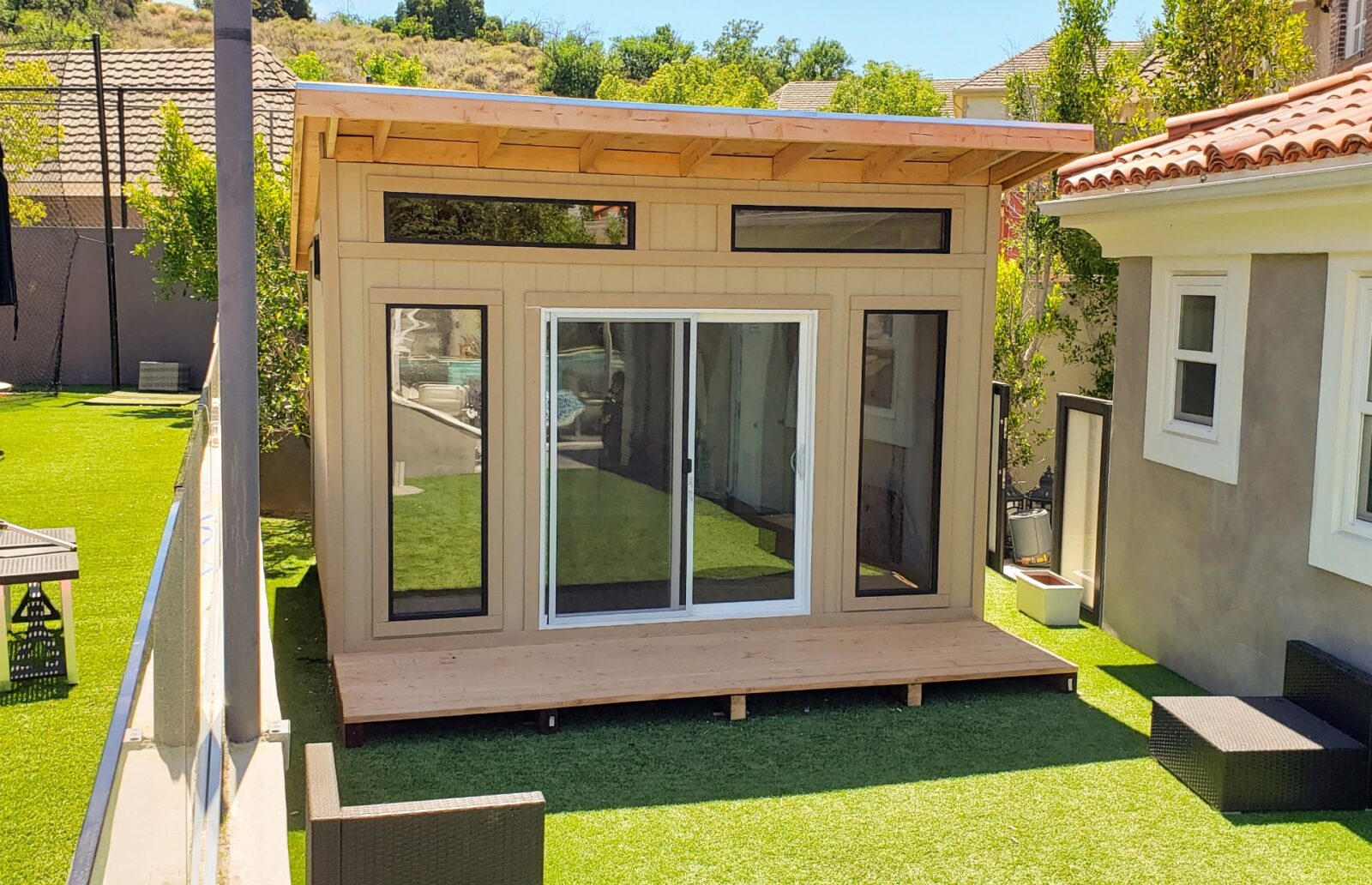 10 x 14 Studio Shed with optional extended front eave, wood deck, patio slider door, and windows